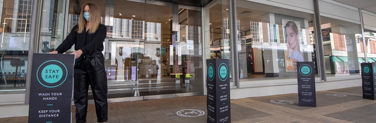 Partner places Covid-19 safety reminder banners outside of the shop